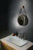 Round bathroom mirror hanging on top of washbasin